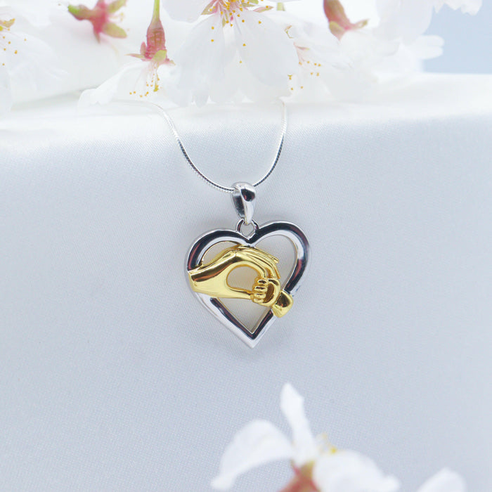 Child Holding Mom Hands Heart Pendant Necklace.